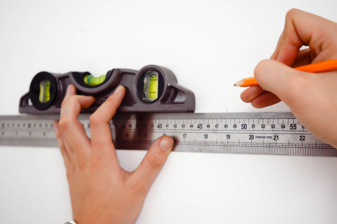 Ruler and spirit level measuring up for wallpaper installation