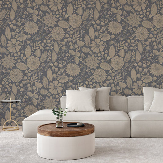 A living room scene with a beige sofa showing 'Jessamine' which is a Blue botanical wallpaper featuring delicate floral blooms, leafy plants and fine botanical illustrations on a dark blue-grey background in a repeating pattern.