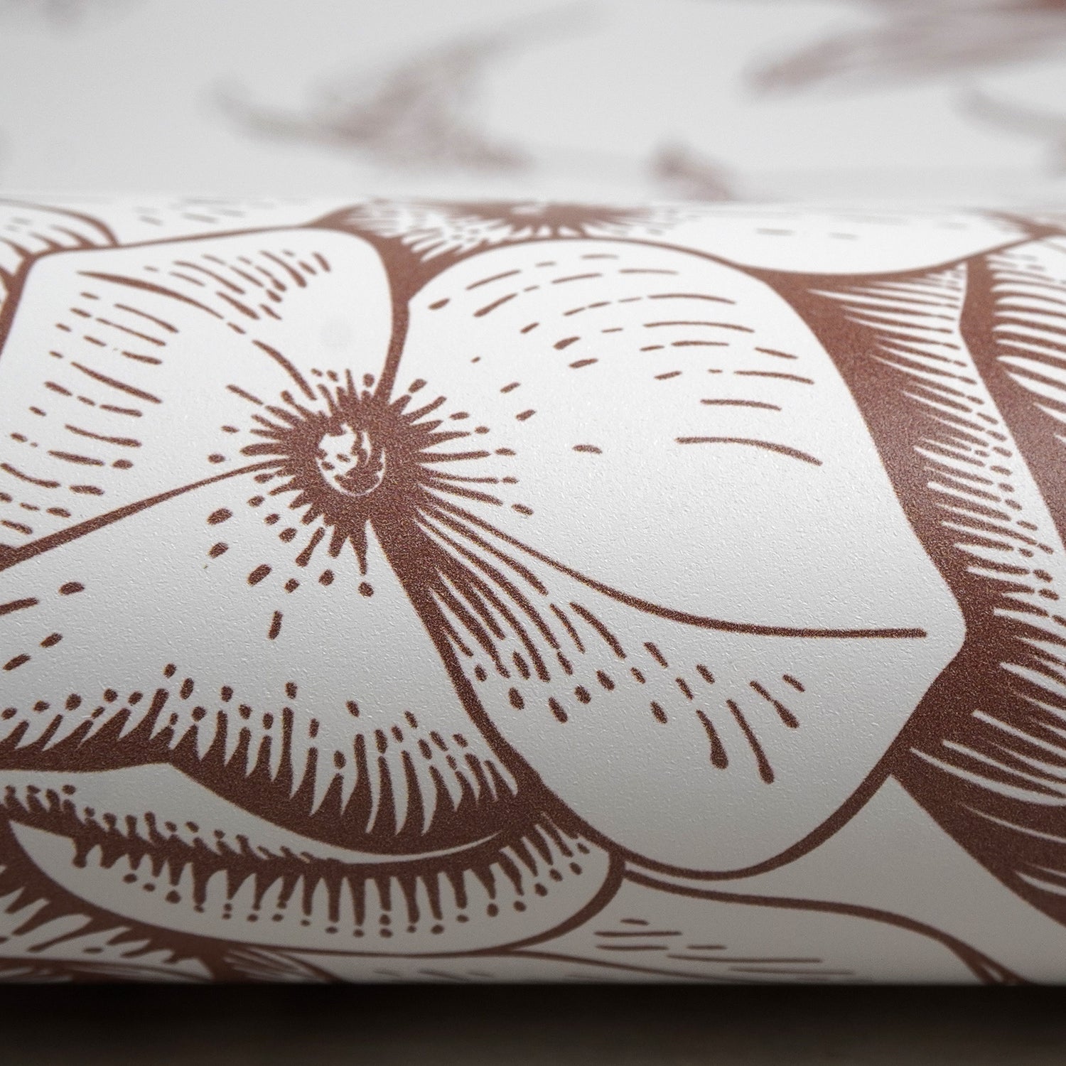 Close up image of the surface of Peel & Paper peel & stick vinyl printed with a brown floral design.