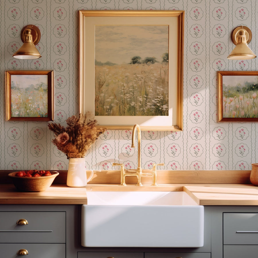 A kitchen with a Bristol sink with photos and lights on the wall showing 'Charlotte' which is a floral striped wallpaper featuring delicate poppy bouquets layered over soft vertical stripes in a charming cottage-inspired repeating pattern.