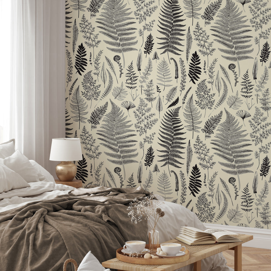A relaxed bedroom showing 'Isidore' which is a vintage botanical wallpaper featuring delicate hand-drawn plants, leaves and foliage in an intricate repeating pattern on a soft neutral background.