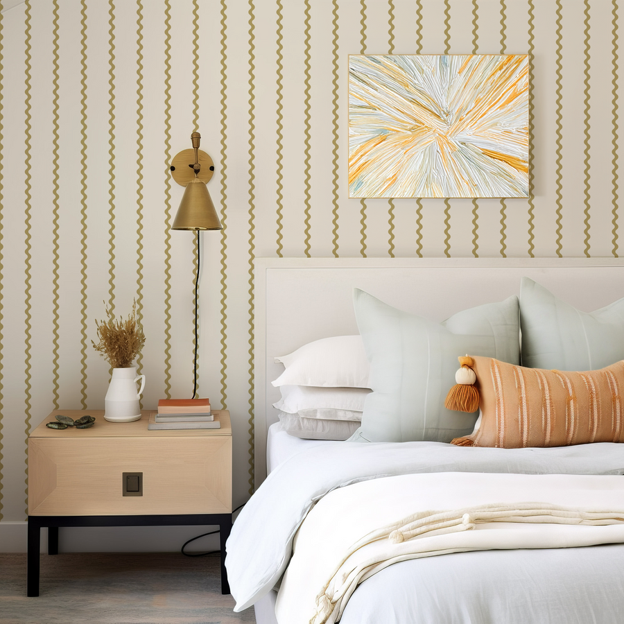 A bedroom with light coloured bed and a side table with a plant and book, with a lamp hanging next to a painting featuring 'Evie' which is a wavy striped wallpaper featuring flowing vertical stripes in soft neutral tones creating a modern repeating pattern with gentle curved lines.