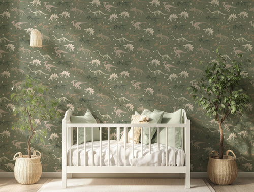 Trixie Dinosaur Wallpaper In Nursery Room With White Cot & Sage Green Cushions With Tree Plants Either Side Of Cot