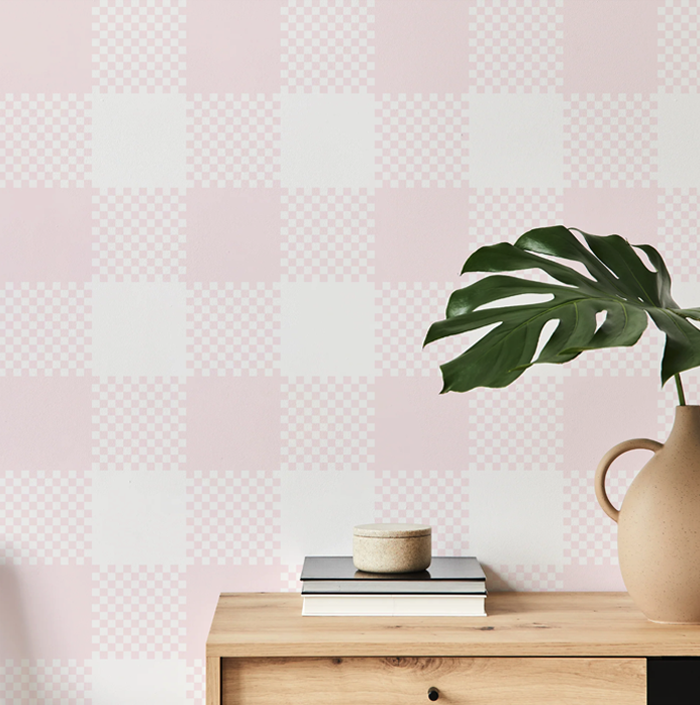 petal pink plaid wallpaper on a hallway wall with an oak console table and monstera