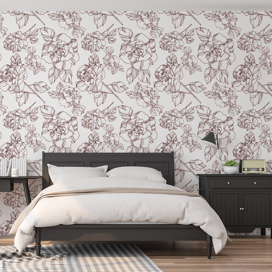 A bedroom with black furniture such as a bed and side tables featuring 'Hailey' which is a floral wallpaper featuring outlined dark red roses with delicate green leaves on a crisp white background in a bold repeating botanical pattern.