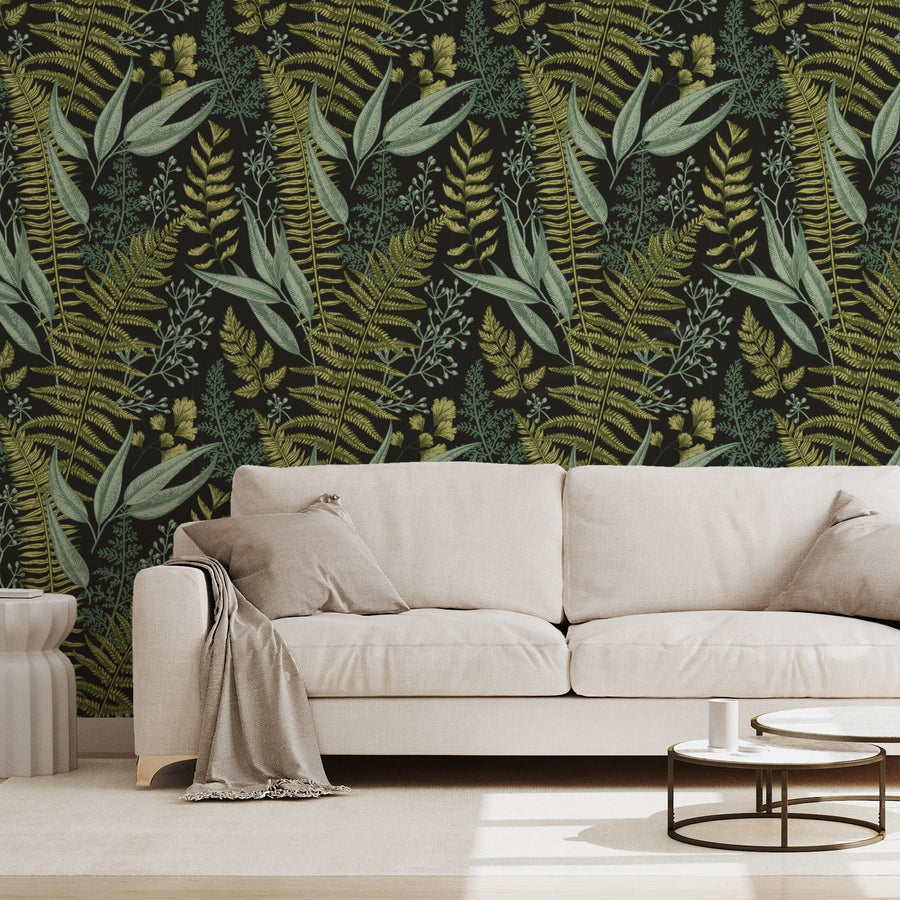 A living room with a cream sofa showing 'Kimberly' which is a vintage wallpaper featuring detailed green leaves and botanical foliage in an intricate repeating pattern on a soft neutral background.